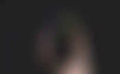 a hand is holding a phone with a podcast app open