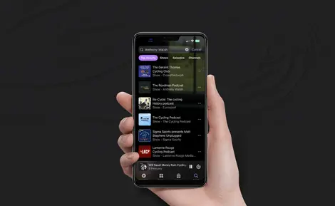 a hand is holding a phone with a podcast app open