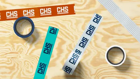 several rolls of chs tape on a wooden surface