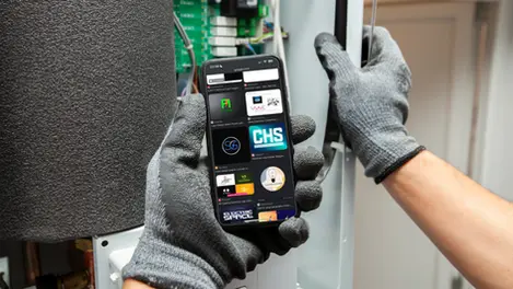 a person wearing gloves is holding a phone that says chs on the screen