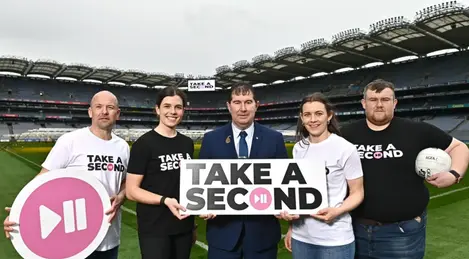 a group of people holding a sign that says take a second