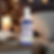 Vaporisateur "Organic Pillow Mist" sur table de chevet, fond de lumières douces et livres ouverts, ambiance relaxante.