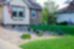 Beautiful residential front yard with decorative rock landscaping and green grass in Rochester, MN.