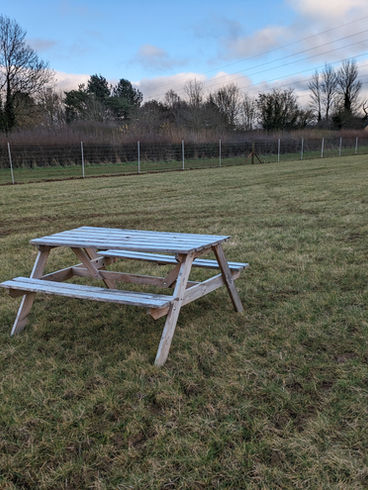 Picnic bench out in the field for people to sit on 
