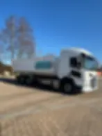 Abrollcontainer-LKW von CR Transporte Mecklenburg auf gepflastertem Hof bei blauem Himmel – bereit für flexible Transport- und Entsorgungsaufgaben.