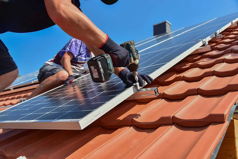 Fachkraft bei der Montage von Solarmodulen auf einem Dach.