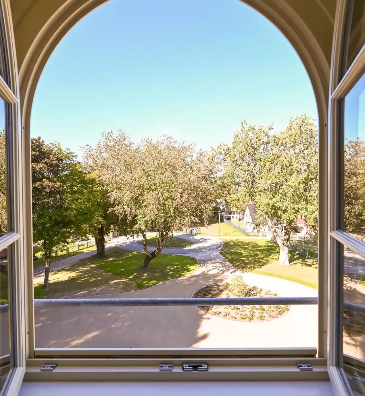 Weitläufiger Ausblick aus einem Fenster der Seniorenresidenz Lehnenhof auf die gepflegte Parkanlage mit altem Baumbestand, Spazierwegen und viel Natur – ruhige Wohnlage in Mecklenburg-Vorpommern.