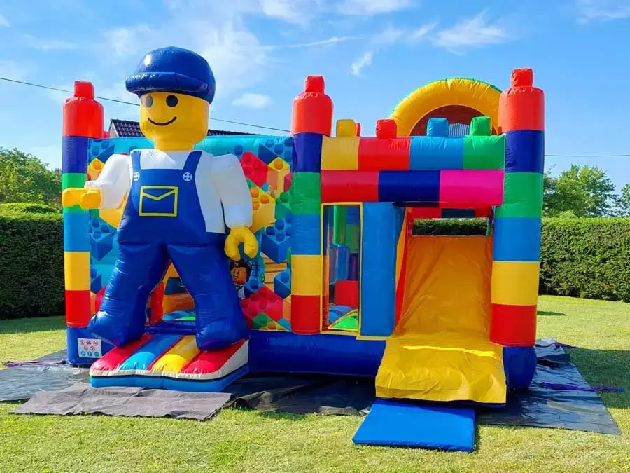 Bunte Hüpfburg in Form einer Spielfigur beim Event im Freien.