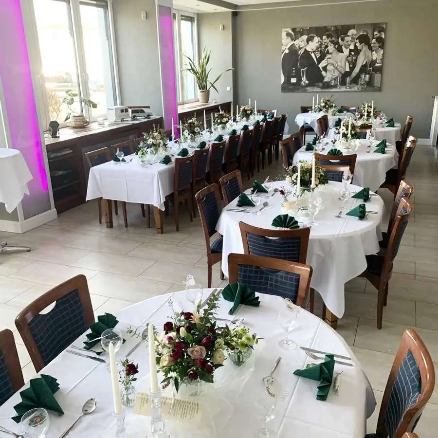 Feiern mit elegant gedeckten runden Tischen und floralen Akzenten in unserer Eventlocation.