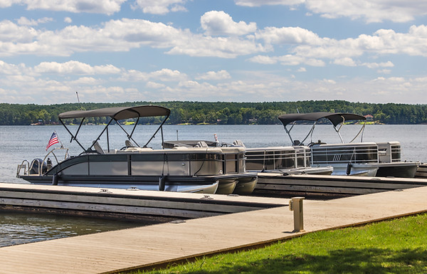 Multiple pontoon boats at marina dock on freshwater lake..jpg