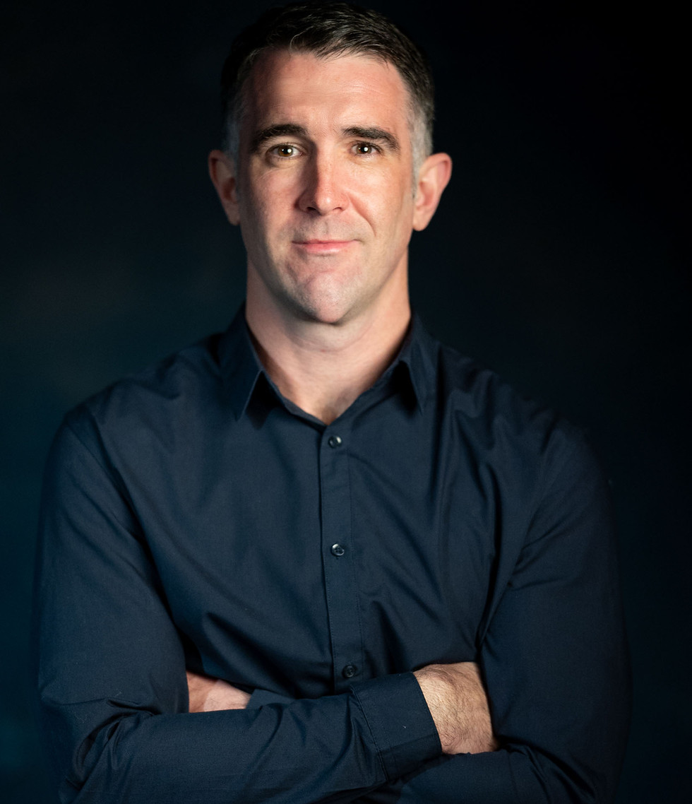 Professional man with dark shirt and arms crossed