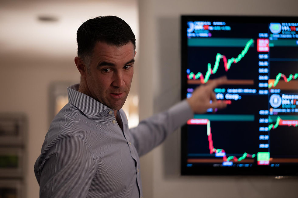 Man pointing at financial charts on a screen