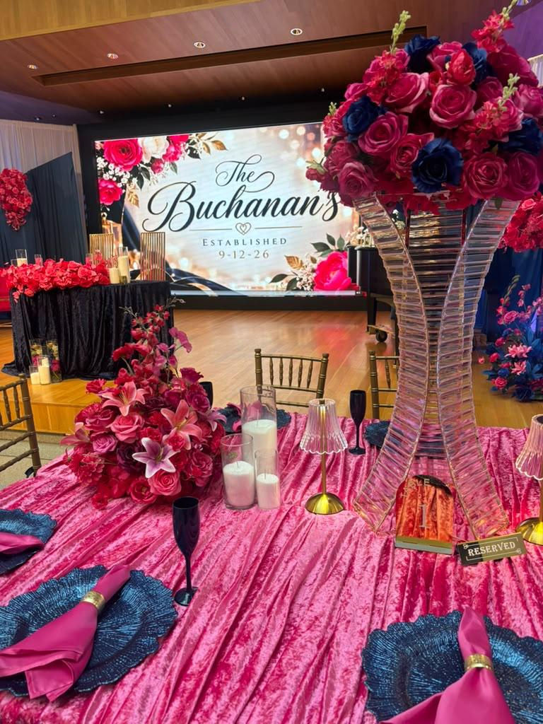 Elegant event venue decorated with vibrant floral arrangements, custom scenic elements and beautifully styled tables.