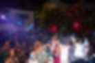A vibrant crowd mingles at a luxurious Miami evening event under a starry sky, celebrating fashion at the Elle Magazine After Party on the Venetian Islands during Miami Swim Week®.