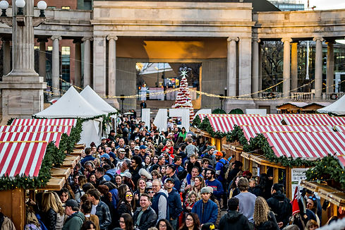 Exterior Christmas themed market with crowds of people walking