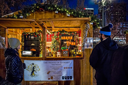 Two people standing outside and looking at a vendor's stall