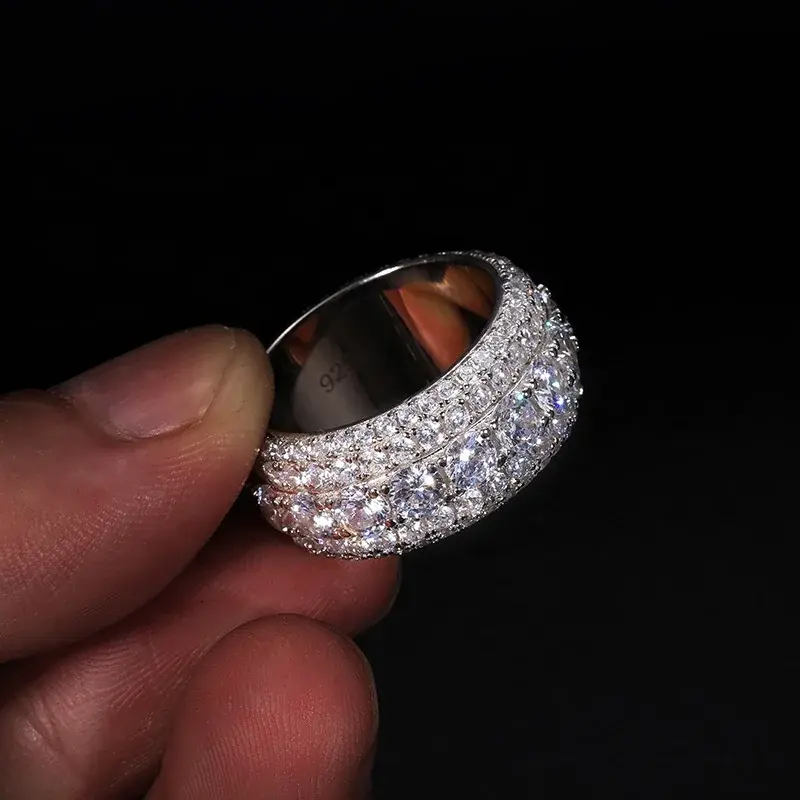 Thumbnail: Hand holding diamond ring, detail shot focus on the jewelry, background black.