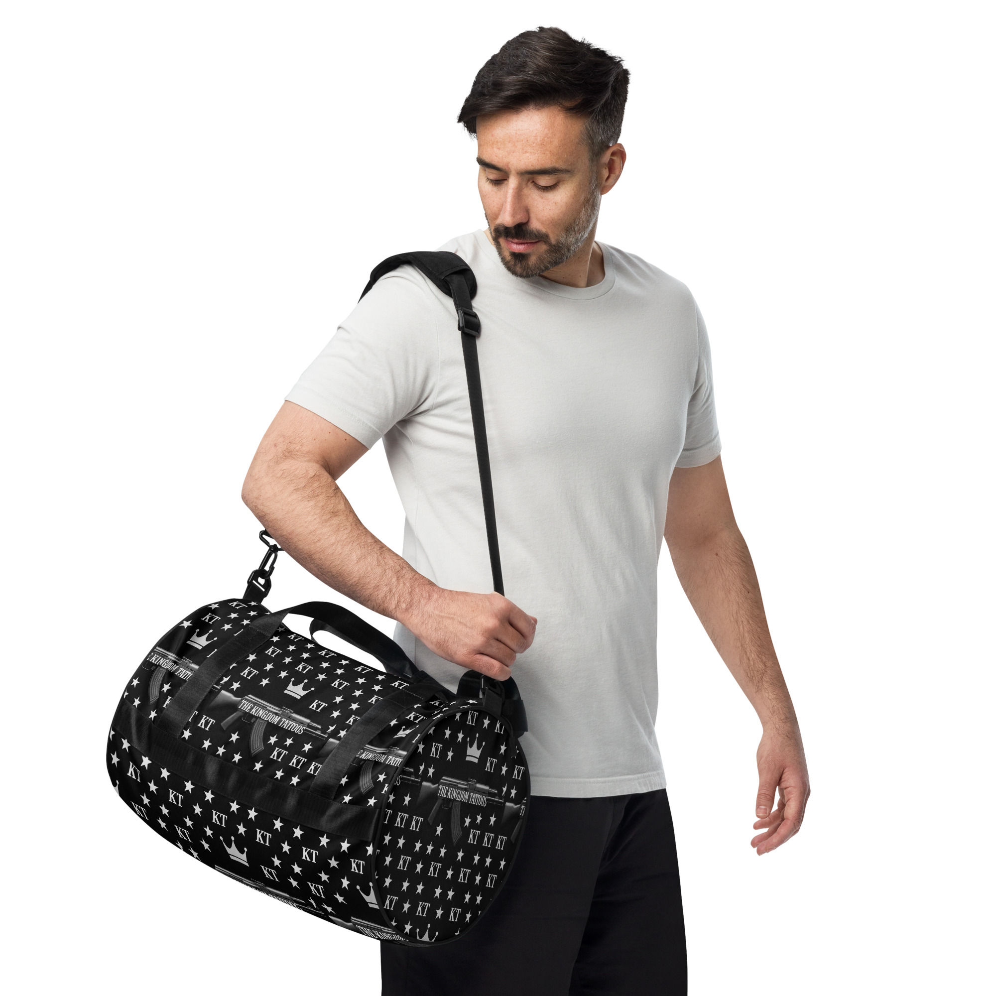 Man carrying a black duffle bag on shoulder; a stylish gym bag.