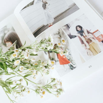 Photobook opened to show contents with flowers laying on top