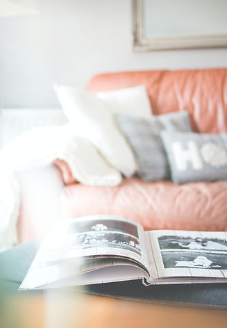 photobook open flat on a coffee table with sofa in background
