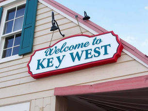A Welcome To Key West sign on a wooden building.