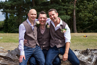 Groom and his best men sitting on the tree stump at Pimhill Barn, Shrewsbury, Shropshire. Taken by candid wedding photographer - Nicki Jones Photography
