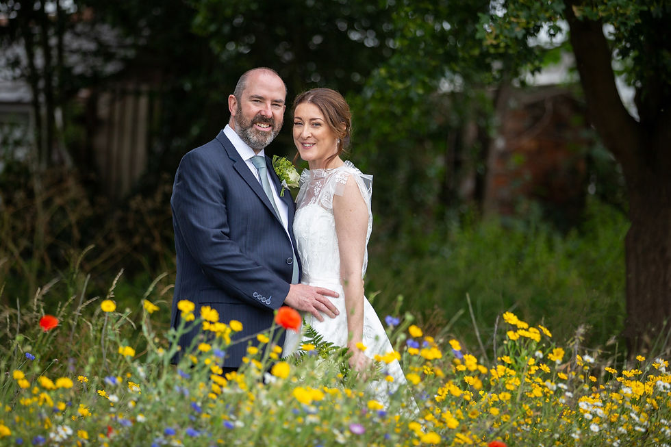 Bride and Groom in wildflower patch having their couples photos taken