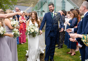 Newly married couple enjoying their confetti moment on their wedding day surrounded by friends and family at Nant Gwrthryn, North Wales. Taken by Shropshire wedding photographer, Nicki Jones Photography