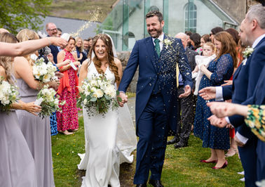 Newly married couple enjoying their confetti moment on their wedding day surrounded by friends and family at Nant Gwrthryn, North Wales. Taken by Shropshire wedding photographer, Nicki Jones Photography