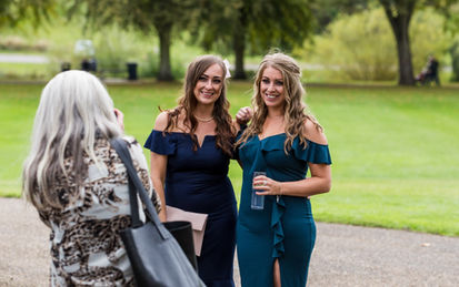 Wedding guests having their photo taken together by another guest during a drinks reception. They are smiling at the woman taking the photo. Candid photograph taken by Nicki Jones Photography, Shrewsbury wedding photographer.