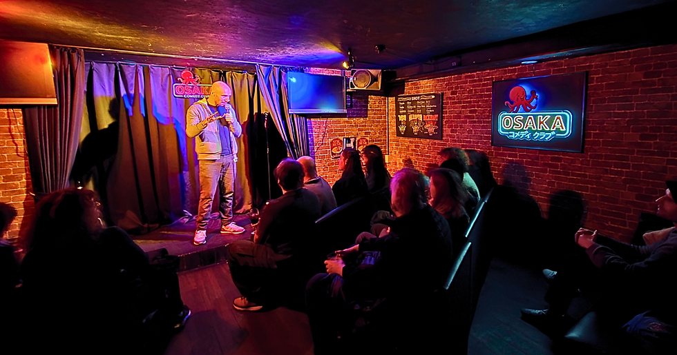 Eye-level view of a bustling comedy club stage in Osaka