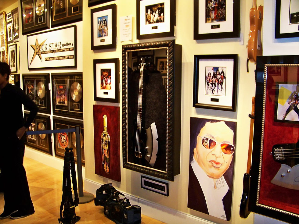Stacey Wells art hung on either side of the Gene Simmon's KISS axe guitar