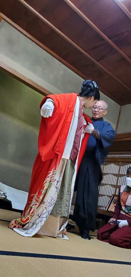 着物に袖を通す人、着物を着付ける人