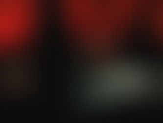 The Puerto Rican rap star Bad Bunny in a white robe with red sunglasses, tied to an altar as menacing shadowy forms lurk in the darkness.