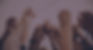 Multiple diverse individuals raising their fists in the air.