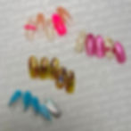 Hands with gel nails on them, with various nail tools placed around on the table