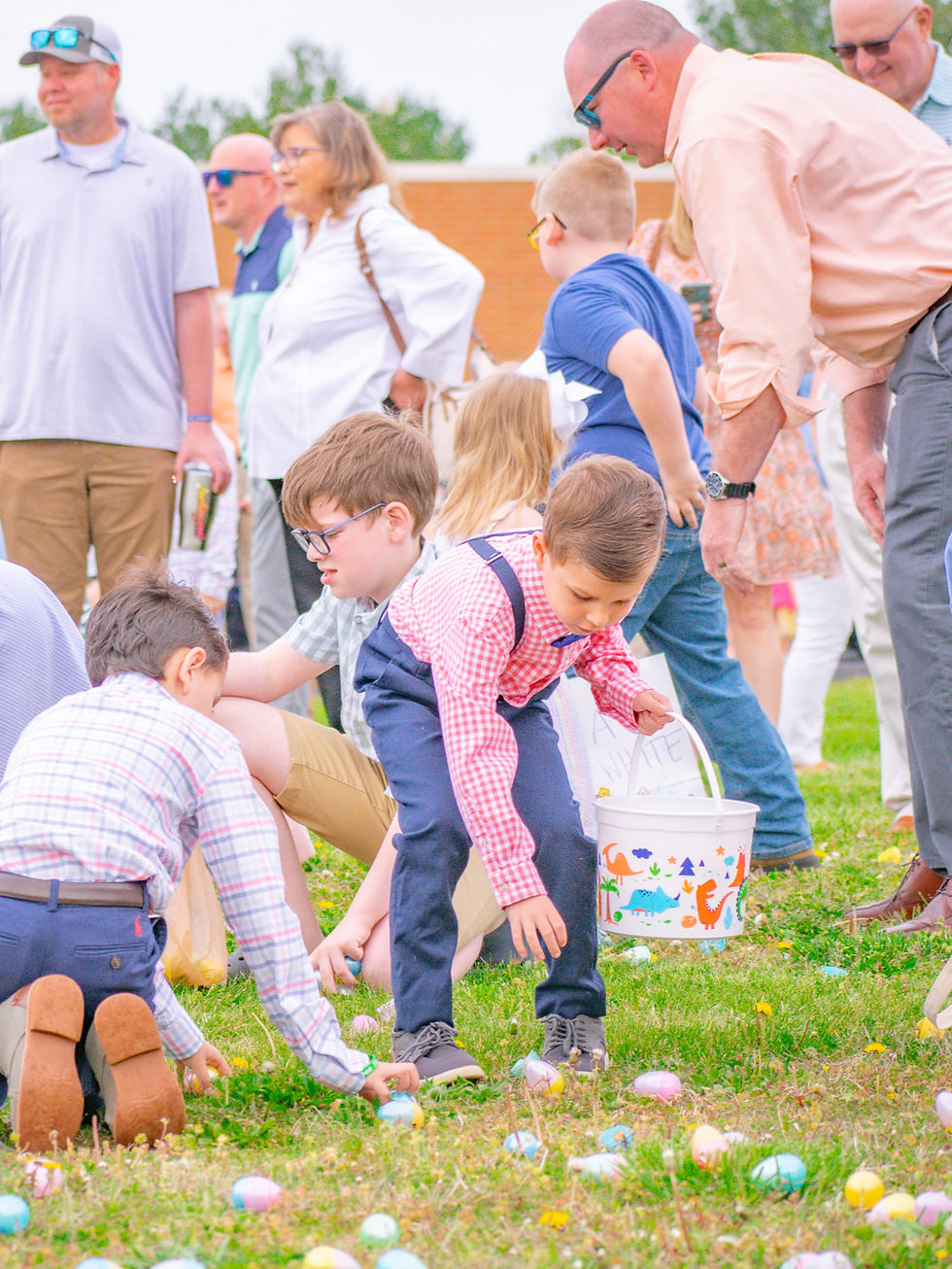 Children and parents running into the field to hunt for Easter eggs.