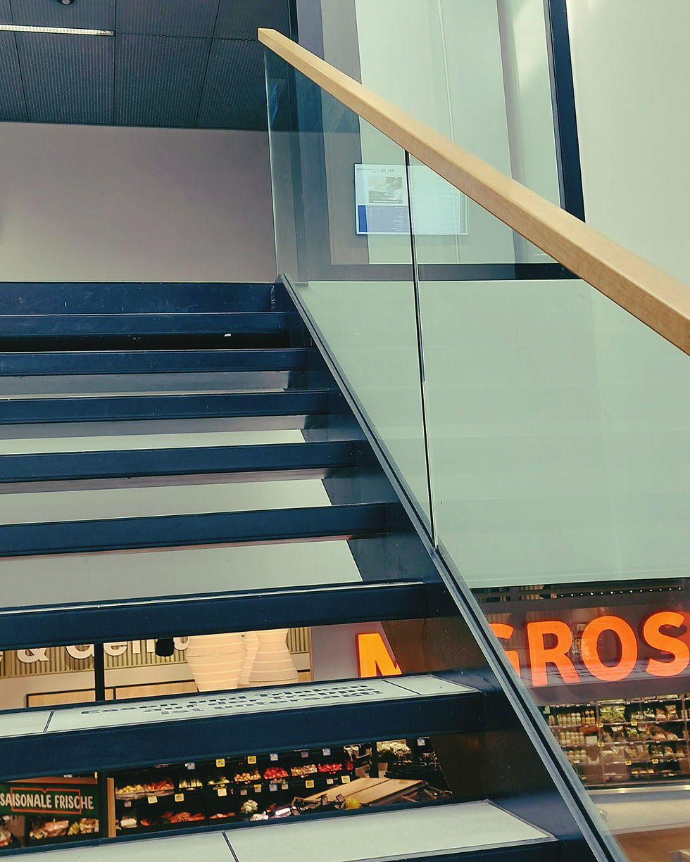 Eine Treppe zu Seminarräumen. Darunter Migros.