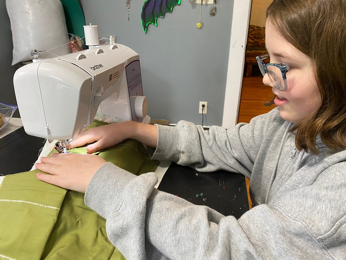 Child sewing on a machine