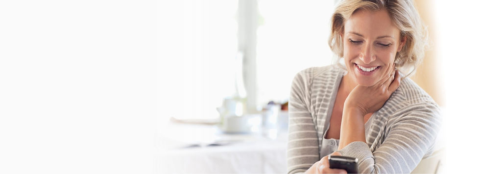 Woman smiling and looking at a cell phone
