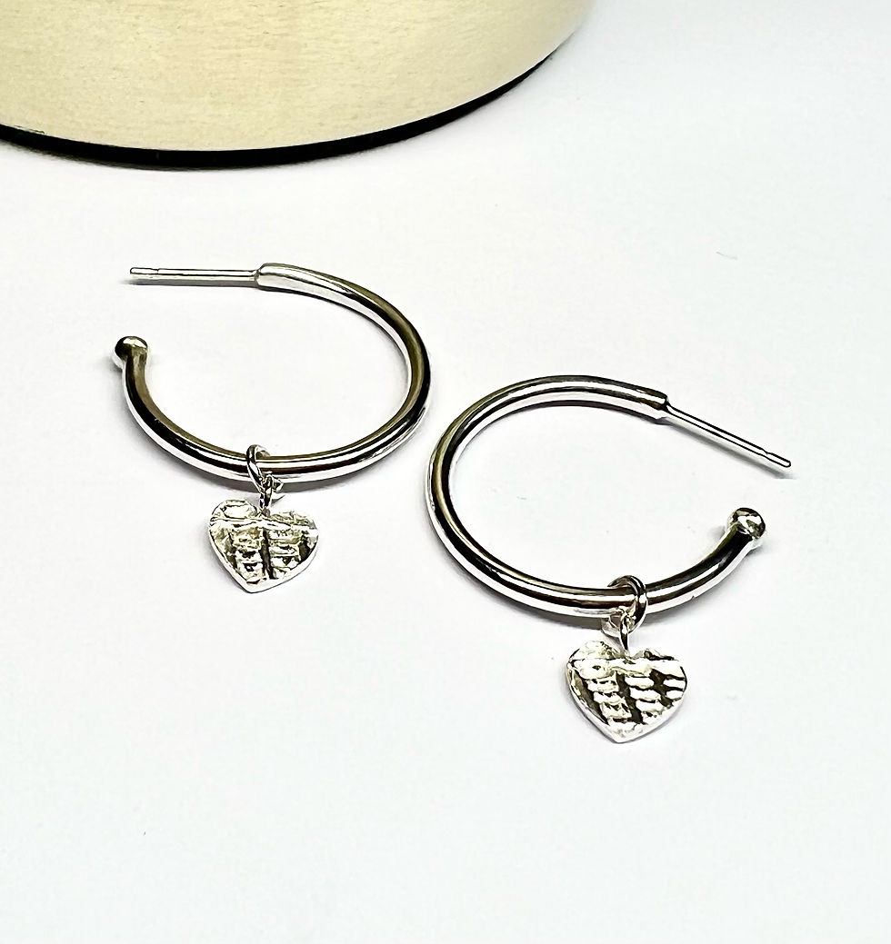 Thumbnail: Handmade Sterling Silver Heart Hoop Earrings on flat surface 