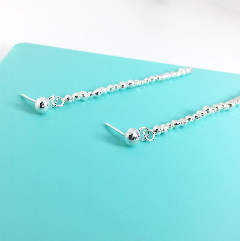 Thumbnail: Handmade Long And Dangly Silver Drop Pebble Earrings
 on flat surface 