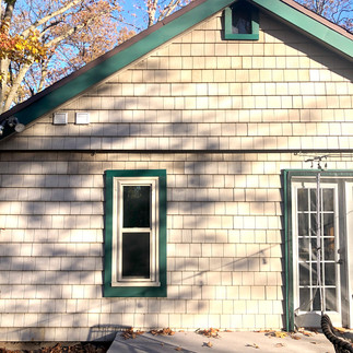 window a/c unit removed from peak and siding patched and repaired on cottage lake house