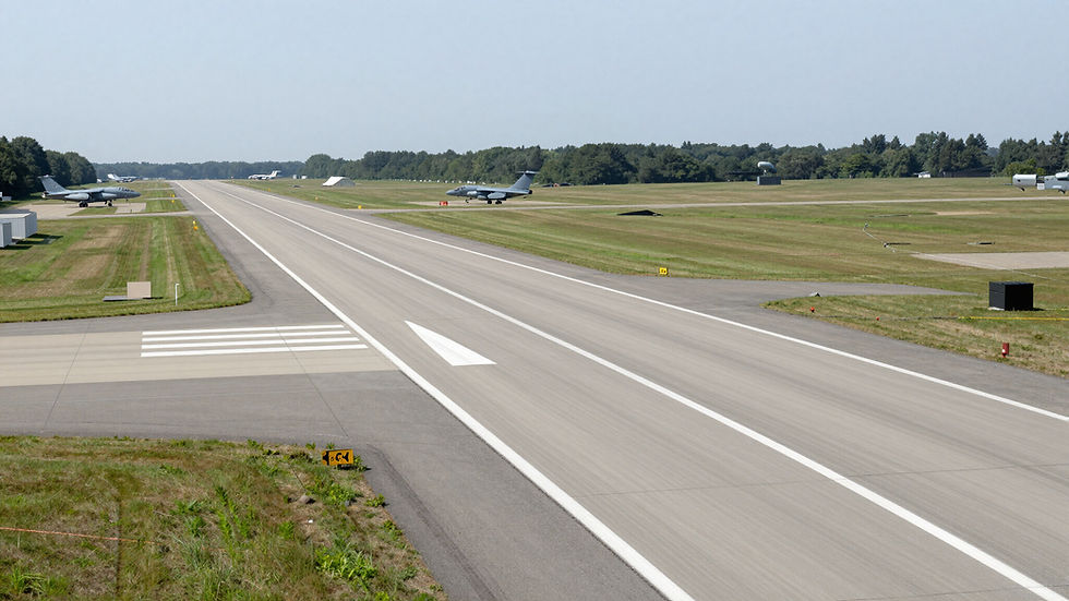 Military airfield runway with parked aircraft