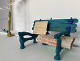 Miniature park bench model with blanket and sign