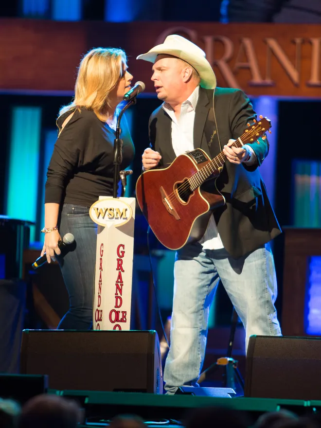 Trisha Yearwood and Garth Brooks performing at the Grand Ole Opry.