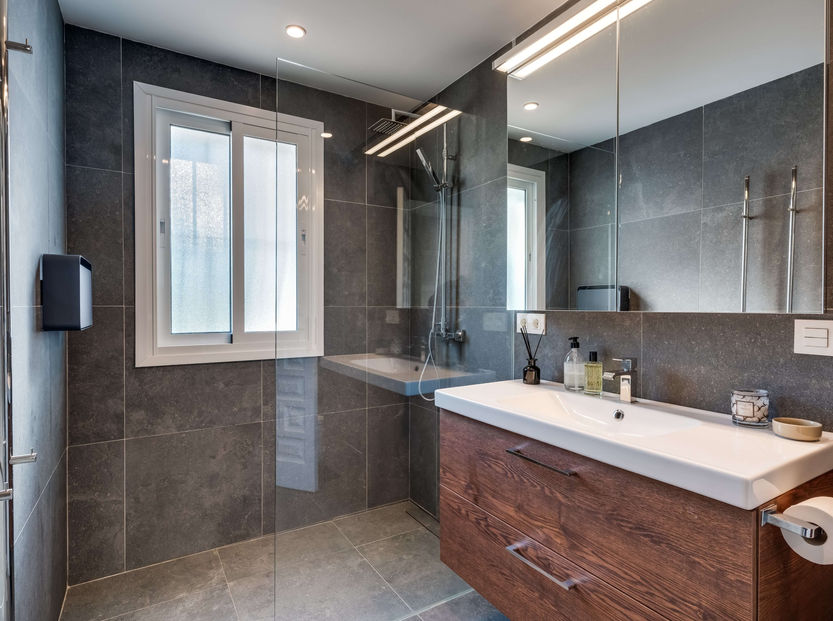 Large en-suite with dual-sink vanity, walk-in shower, and natural light