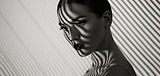 Black and white portrait of a beautiful young girl with a shadow pattern on the face and b