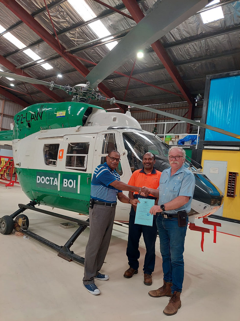 CASAPNG Inspector Peter Kukuma (left) handing over the Certificate of Airworthiness for P2-LAW to Manolos Aviation CEO Jurgen Ruh. The small but significant gesture was witnessed by staff including Manolos maintenance manager Daniel Tira (centre) on June 26th.