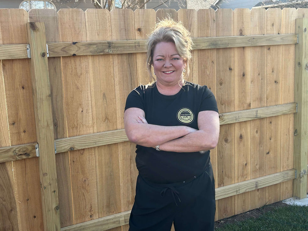 Brandi Hall in front of fence with arms crossed